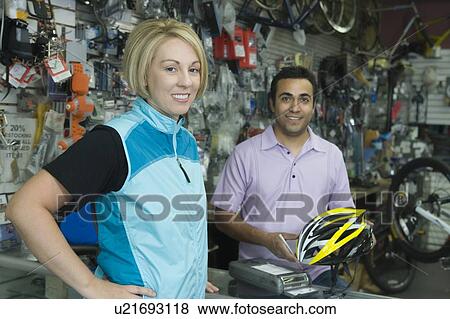 Female cyclist buying helmet at bike shop cash desk View Large Photo Image Stock Photo - Female cyclist buying helmet at bike shop cash desk. Fotosearch