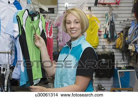 Female cyclist in bike shop choosing cycling top View Large Photo Image Picture - Female cyclist in bike shop choosing cycling top. Fotosearch