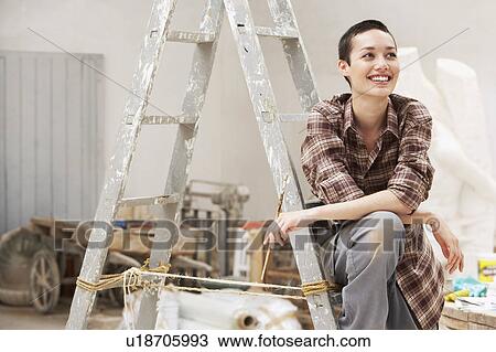 Female interior decorator sitting on ladder in work site, front view View Large Photo Image Stock Image - Female interior decorator sitting on ladder in work site, front view. Fotosearch