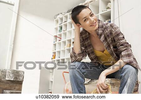 Female painter on Work Break in tool room, portrait, low angle view View Large Photo Image Stock Photo - Female painter on Work Break in tool room, portrait, low angle view. Fotosearch
