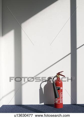 Stock Photo - Fire extinguisher casting shadow on wall. Fotosearch