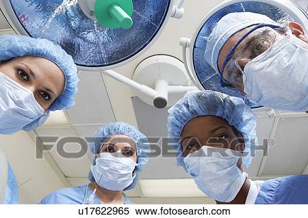 Four surgeons looking down, low angle view View Large Photo Image Stock Photography - Four surgeons looking down, low angle view. Fotosearch