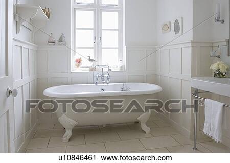 Stock Image - Freestanding roll top in panelled bathroom, London. Fotosearch