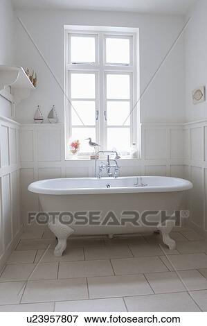 Stock Photo - Freestanding roll top in panelled bathroom, London. Fotosearch
