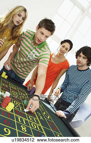 Friends Gambling on roulette table View Large Photo Image Stock Image - Friends Gambling on roulette table. Fotosearch