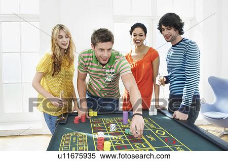 Stock Photography - Friends Gambling on roulette table. Fotosearch