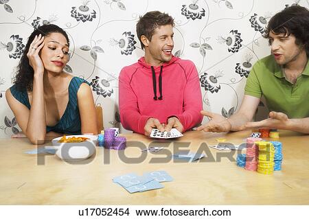 Picture - Friends Playing Cards, man showing winning hand. Fotosearch