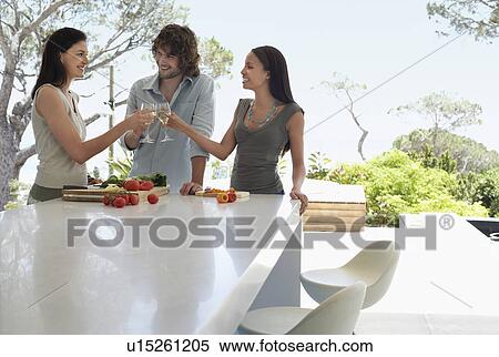 Friends socialising, toasting at end of outdoor counter at Dinner Party View Large Photo Image Stock Photography - Friends socialising, toasting at end of outdoor counter at Dinner Party. Fotosearch