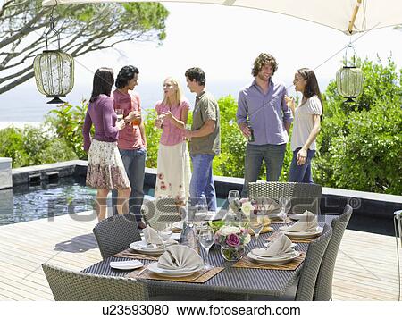 Friends standing outside, drinking, near a set table View Large Photo Image Stock Image - Friends standing outside, drinking, near a set table . Fotosearch