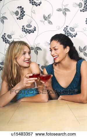 Stock Photo - Friends toasting Martinis at table. Fotosearch
