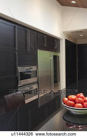 Stock Photograph - Fruitbowl of apples in black gloss kitchen. Fotosearch