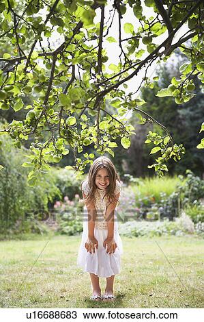 Girl (10-12) smiling in garden View Large Photo Image Stock Image - Girl (10-12) smiling in garden. Fotosearch