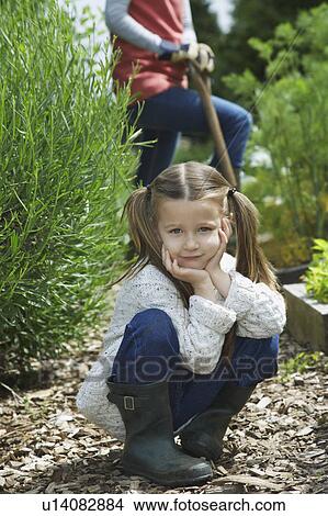 Girl (5-6) in garden with mother (mid section), portrait View Large Photo Image Picture - Girl (5-6) in garden with mother (mid section), portrait. Fotosearch