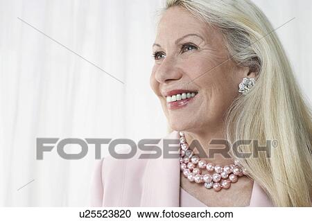Glamorous senior woman in studio, head and shoulders View Large Photo Image Stock Image - Glamorous senior woman in studio, head and shoulders. Fotosearch