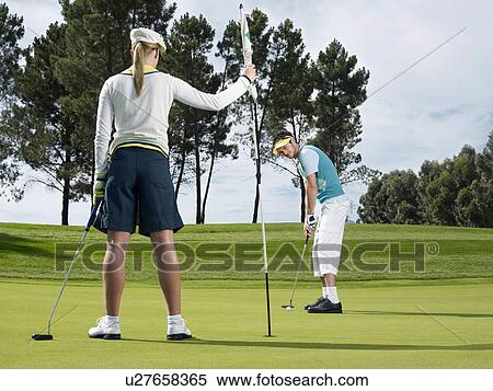 Stock Photography - Golfer putting. Fotosearch