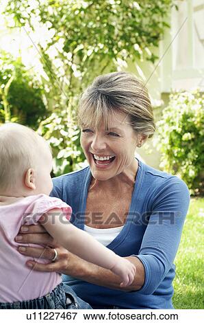 Grandmother and granddaughter in garden, half length View Large Photo Image Stock Photo - Grandmother and granddaughter in garden, half length. Fotosearch