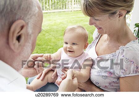 Grandparents playing with granddaughter in garden View Large Photo Image Stock Photo - Grandparents playing with granddaughter in garden. Fotosearch