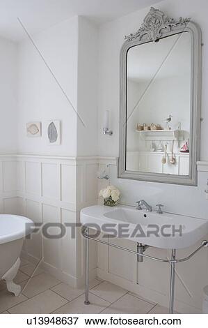 Stock Photo - Grey painted mirror surround in panelled bathroom, London. Fotosearch