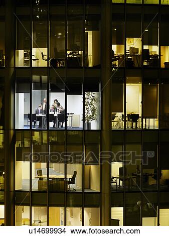 Group of business people at meeting in office, view from building exterior View Large Photo Image Picture - Group of business people at meeting in office, view from building exterior. Fotosearch