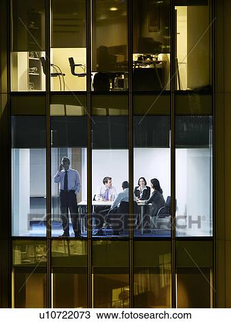 Group of business people at meeting in office, view from building exterior View Large Photo Image Stock Image - Group of business people at meeting in office, view from building exterior. Fotosearch