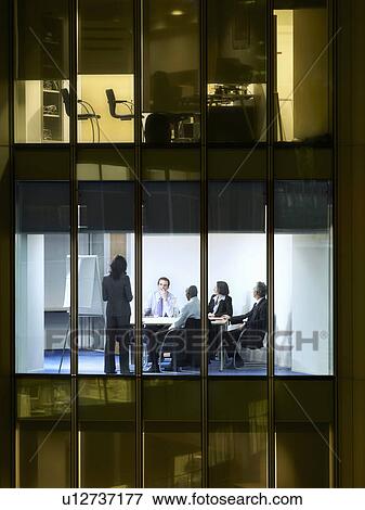 Stock Photo - Group of business people at meeting in office, view from building exterior. Fotosearch
