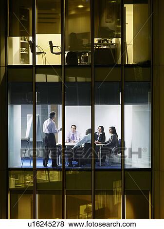 Stock Photo - Group of business people at meeting in office, view from building exterior. Fotosearch