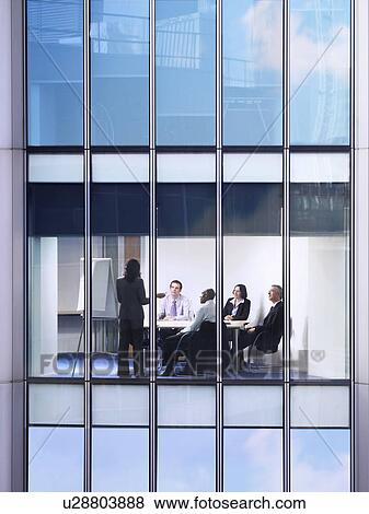 Group of business people at meeting in office, view from building exterior View Large Photo Image Stock Photo - Group of business people at meeting in office, view from building exterior. Fotosearch