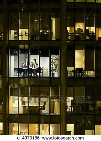 Group of business people at meeting in office, view from building exterior View Large Photo Image Stock Photograph - Group of business people at meeting in office, view from building exterior. Fotosearch