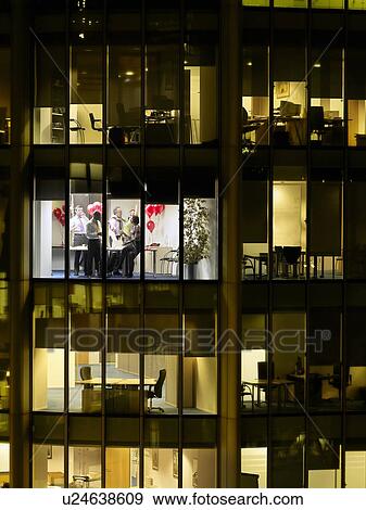 Stock Photo - Group of business people having office party, view from building exterior. Fotosearch