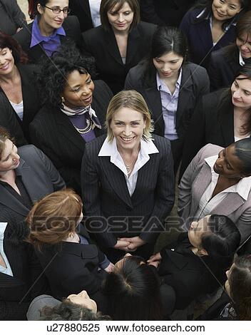Group of business women looking at woman standing in middle, elevated view View Large Photo Image Stock Photography - Group of business women looking at woman standing in middle, elevated view. Fotosearch