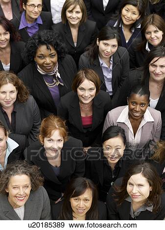 Stock Photo - Group of business women looking up, portrait, elevated view, close up. Fotosearch
