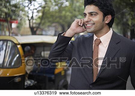 India, business man using mobile phone on street View Large Photo Image Stock Photo - India, business man using mobile phone on street. Fotosearch
