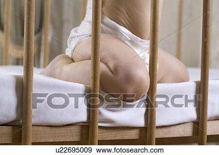 INfant child kneeling in cot View Large Photo Image Stock Photo - INfant child kneeling in cot. Fotosearch