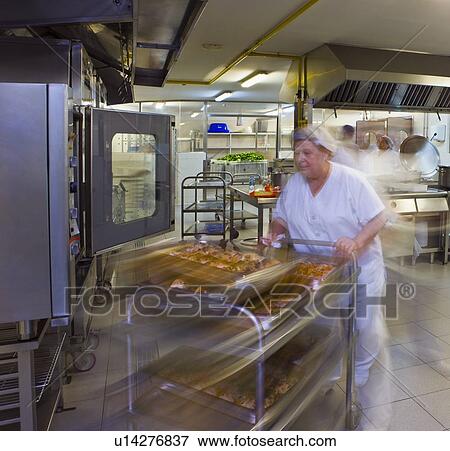 Kitchen porter pushes a trolley of pastries View Large Photo Image Stock Photo - Kitchen porter pushes a trolley of pastries. Fotosearch