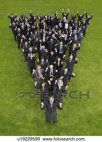 Stock Photo - Large group of business people standing in triangle formation, cheering, elevated view. Fotosearch