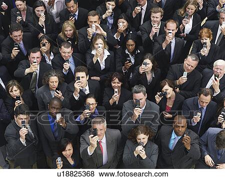 Large group of business people taking photographs with mobile phones, elevated view View Large Photo Image Stock Photo - Large group of business people taking photographs with mobile phones, elevated view. Fotosearch