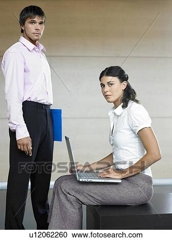 Male and female office workers standing in lobby, portrait View Large Photo Image Stock Image - Male and female office workers standing in lobby, portrait. Fotosearch