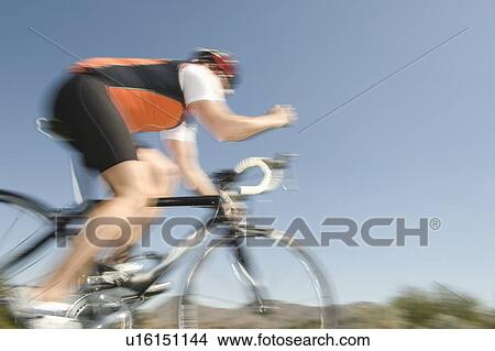 Picture - Male cyclist, blurred motion. Fotosearch