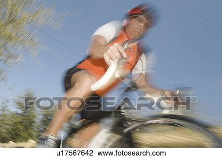 Stock Image - Male cyclist, blurred motion. Fotosearch