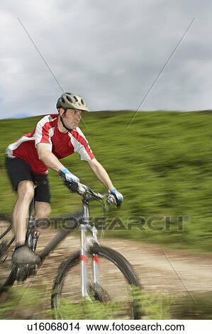 Picture - Male cyclist on track in countryside. Fotosearch