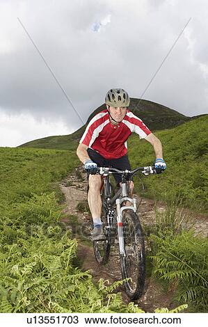 Male cyclist on track in countryside View Large Photo Image Stock Image - Male cyclist on track in countryside. Fotosearch