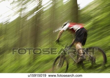 Stock Photo - Male cyclist on track in countryside. Fotosearch