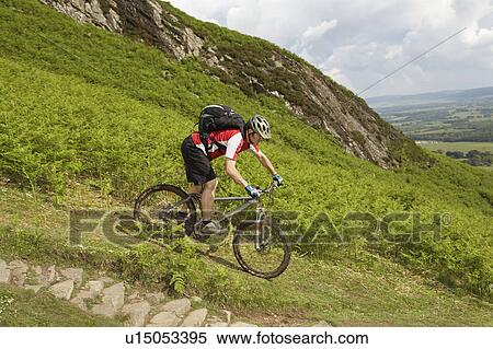 Stock Photography - Male cyclist on track in countryside. Fotosearch