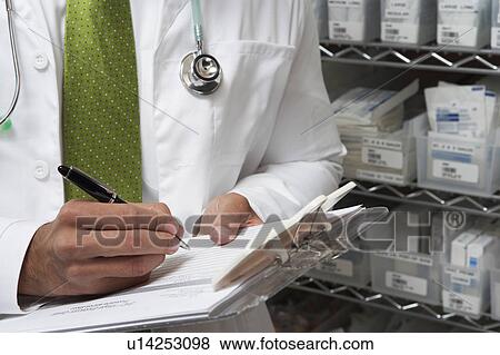 Stock Photo - Male doctor writing in patient chart, mid section. Fotosearch