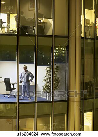 Picture - Male surgeon standing in office, view from building exterior. Fotosearch
