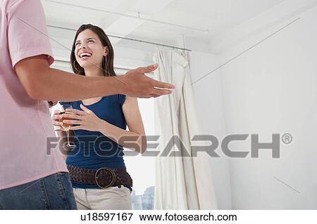 Stock Photo - Man and woman talking in living room. Fotosearch