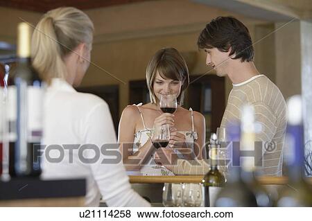 Stock Photo - Man and woman wine-tasting, selective focus. Fotosearch