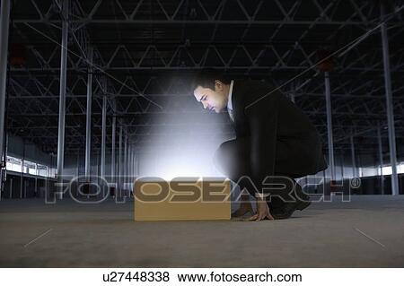 Man peers into yellow box shining bright light View Large Photo Image Stock Photo - Man peers into yellow box shining bright light. Fotosearch