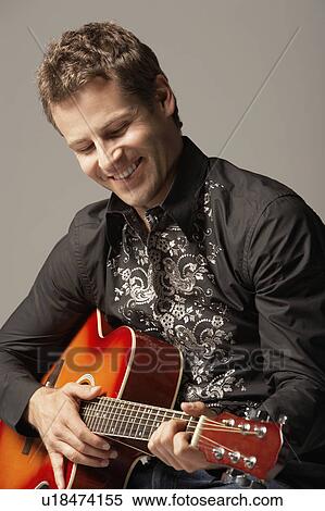 Stock Photography - Man Playing Guitar, smiling, close-up. Fotosearch