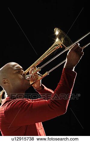 Stock Photo - Man Playing Trombone, close-up, side view. Fotosearch